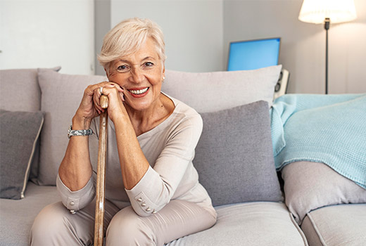 Woman smiling and leaning on cane
