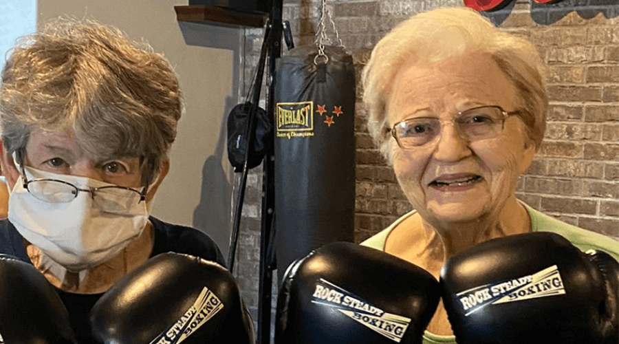 Two female residents wearing boxing gloves