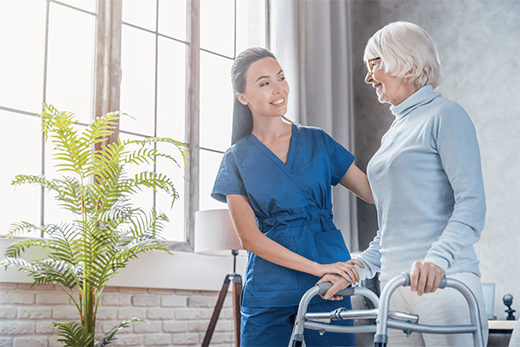 Female physical therapist assisting a senior female stand up